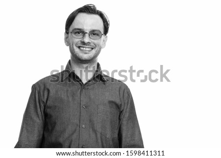 Studio shot of formal young happy man smiling while wearing eyeglasses