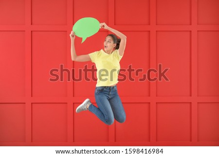 Jumping young woman with speech bubble against color background