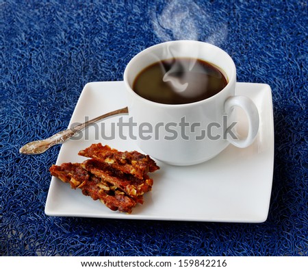 Homemade marshmallows with nuts and a cup of coffee on navy blue background