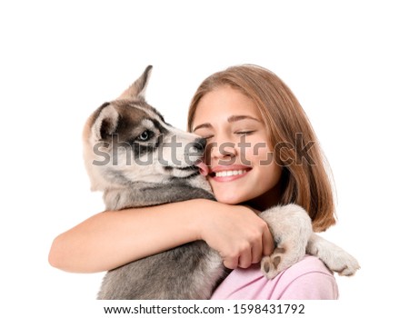Cute teenage girl with funny husky puppy on white background
