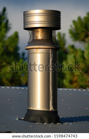 View of double-walled cylindrical metal woodburner chimney