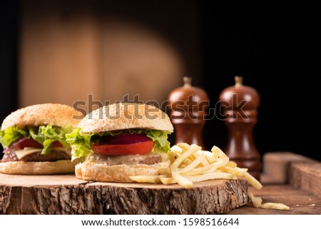 A fresh tasty burger and french fries on wooden table
