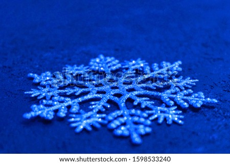 
Christmas background. Big silver snowflake on a blue background. Copy space. Minimalistic design.