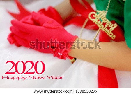 Very blurred. Happy New Year 2020. The title, the text and the decoration are dressed in Christmas. The red gloves. To send happiness New year greeting card