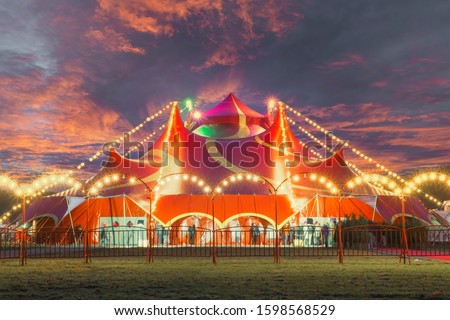Night view of a circus tent under a warn sunset and chaotic sky Royalty-Free Stock Photo #1598568529