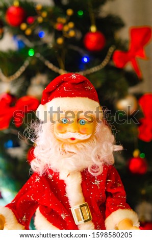 Toy Santa Claus, on the background of the New Year tree, and on the background of the New Year star on the Christmas tree. Toy Santa in close-up. Christmas decoration. Celebration