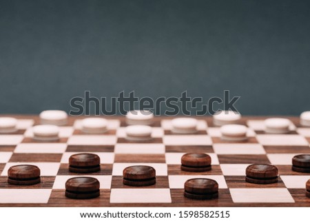 Selective focus of checkers on checkerboard isolated on grey