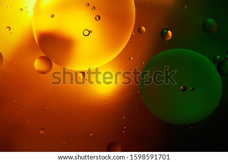 abstract background from mixed water and oil in orange and green color