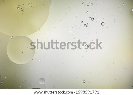 Beautiful background from mixed water and oil bubbles in light green and grey color