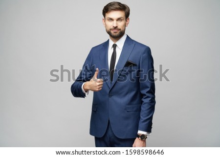 young business man going thumb up on grey background
