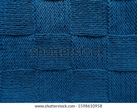 Knitted texture for the background, classic blue 2020. cozy knitted background.  geometric pattern, handmade.  close up, flat lay, top view, copy space