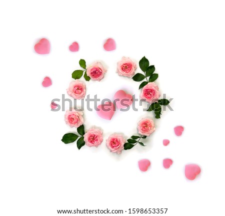 Decoration of Valentine Day. Beautiful flowers pink roses and pink hearts on white background. Top view, flat lay