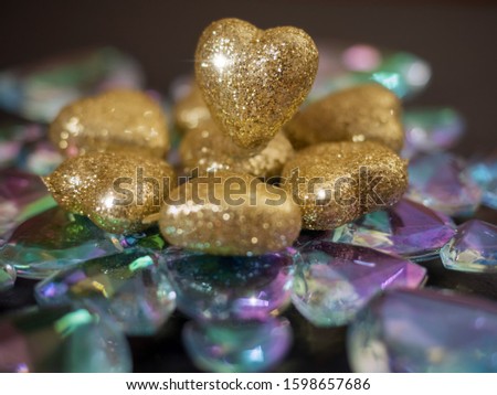 Golden hearts with glitter on a glass snowflake, Saint Valentine theme background.