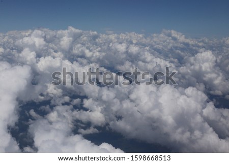 View from above of pattern of white clouds. Cloudscape with vivid blue sky in background. Natural texture with stratus and cumulus. Natural picture of the sky.