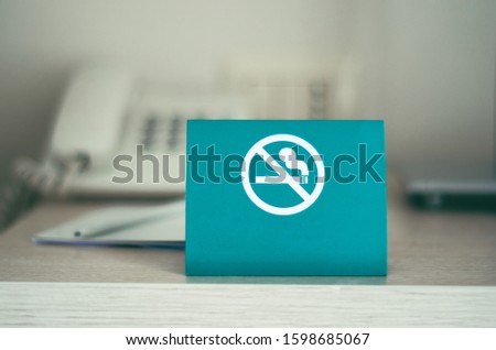 No smoking sign on a shelf of hotel room. Concept photo of banning smoking in public area, medical, health