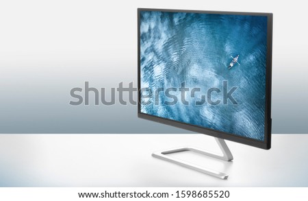 Computer monitor with a photo of the sea on a white surface