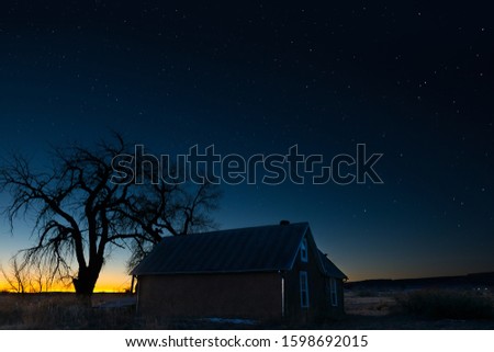 A beautiful scenery of a house under the magical night sky