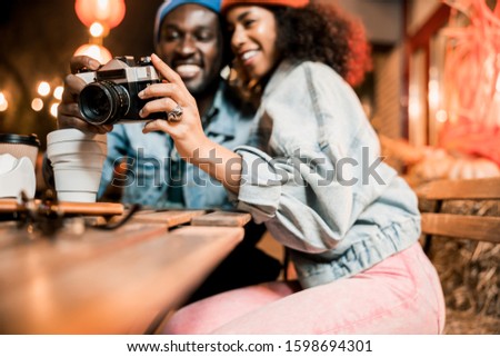 Happy Afro American man and woman viewing photos in street cafe stock photo