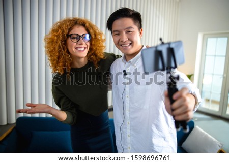 Waist up of Asian man standing with pretty lady while posing at camera stock photo