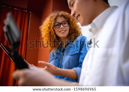 Beautiful young woman looking at man while talking with him stock photo
