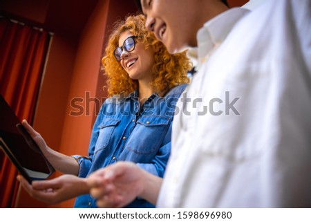 Cropped photo of two smiling employees looking at tablet screen stock photo