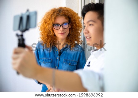 Male blogger recording video content while looking at camera stock photo