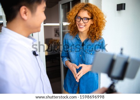 Happy man looking at smiling lady while recording video stock photo