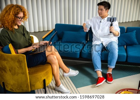 Happy lady typing on laptop while sitting in the armchair stock photo