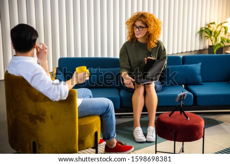 Young man looking away while recording interview stock photo