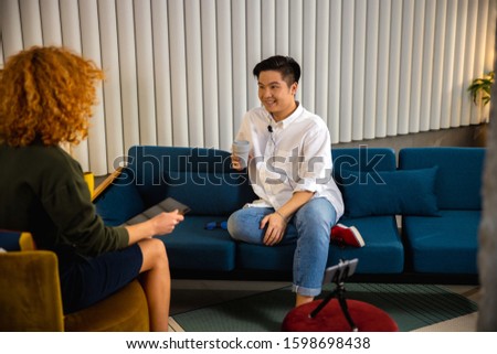 Smiling Asian man during recording vlog in office stock photo