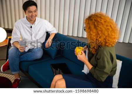 Happy man holding coffee while recording interview stock photo