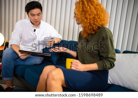 Asian guy with coffee holding laptop in the office stock photo