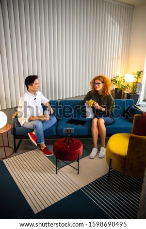 Female blogger having an interview on sofa stock photo