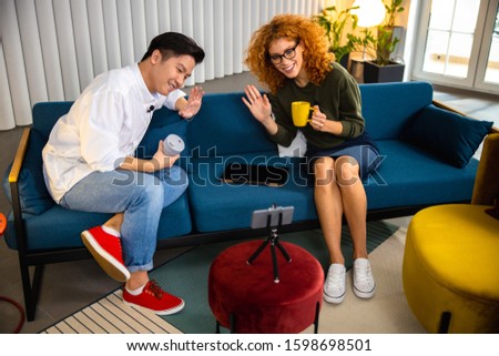 Smiling two employees recording vlog in office stock photo