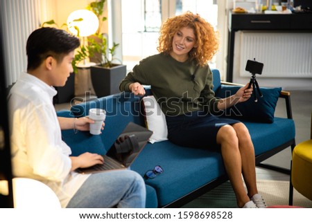 Asian man with hot drink using laptop in office stock photo