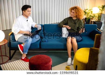 Happy Asian man sitting on a couch during an interview stock photo
