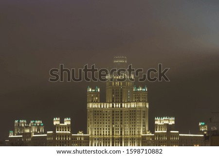 Photography of Stalinist skyscraper on Kotelnicheskaya embankment in winter night. The spire hiding in the fog. International touristic concepts. 