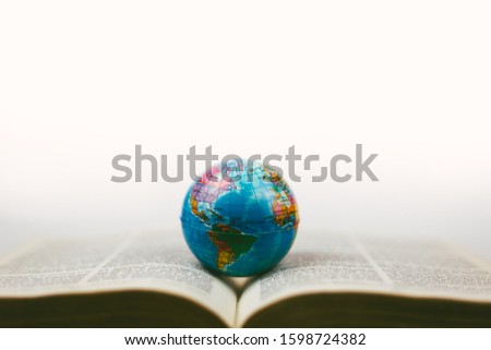 soft focus vintage globe with open Bible and magnifying glass, a missions concept.