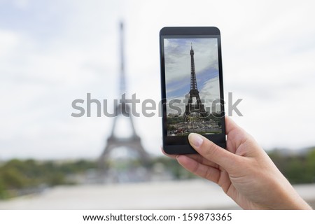 Woman in Paris taking pictures in front of Eiffel Tower, Cell phone