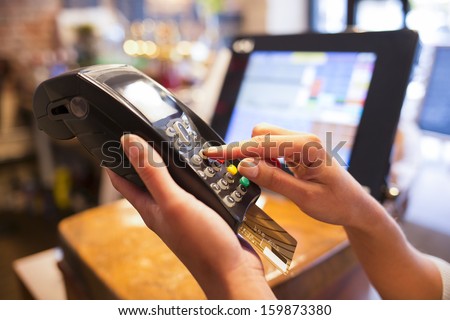 Woman hand with credit card swipe through terminal for sale in restaurant Royalty-Free Stock Photo #159873380