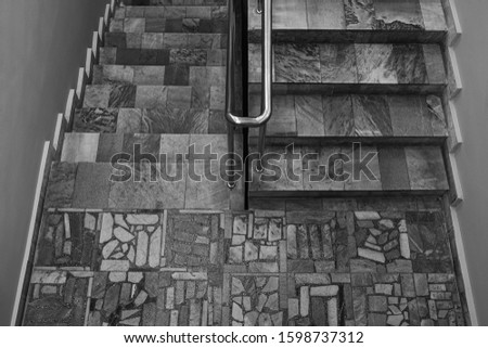 Black and white staircase made of granite tiles in the building.