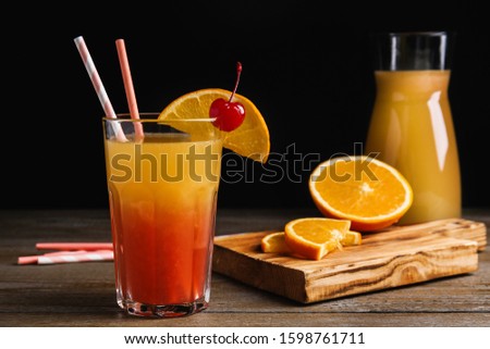 Fresh alcoholic Tequila Sunrise cocktail on wooden table