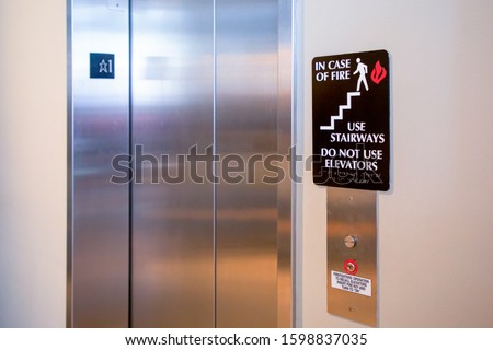 Do not use elevator in case of fire sign beside the elevator. safety concept.