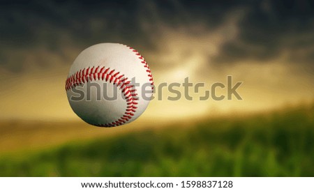 Baseball ball in the air. Close-up. Evening sunset. Blurred background