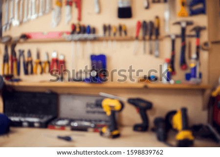 A lot of different tools for repair and manufacturing service in work office. Blurred picture