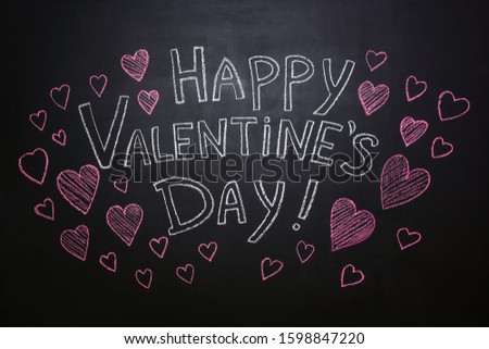 Lettering "Happy Valentine's Day" and red hearts are drawn in chalk on a blackboard.
