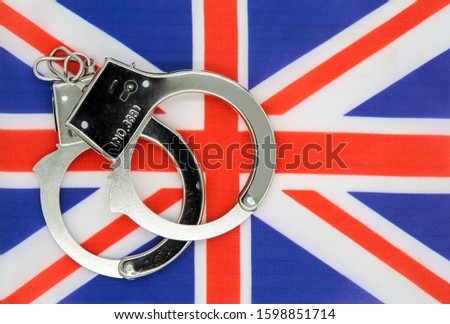England flag and police handcuffs. The concept of crime in the country.