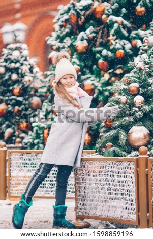 Little beautiful girl on the christmas market outdoors