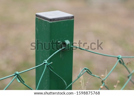 Green screw on the pole to hold the wire fence