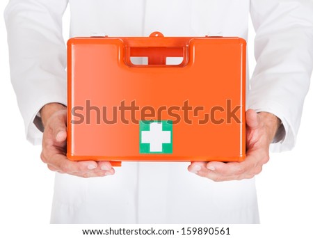 Close-up Of Male Doctor Holding First Aid Box Over White Background